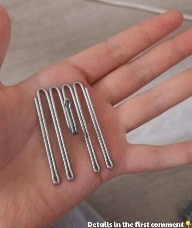 Close-up of a vintage stainless steel curtain hook, commonly used to hang heavy curtains in homes during the mid-20th century