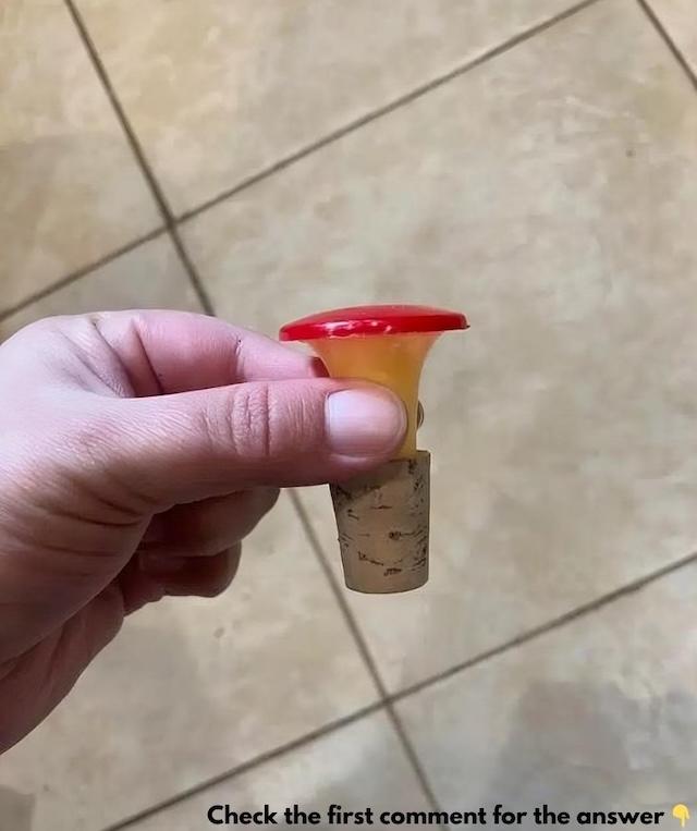 A vintage red and white sprinkler bottle top that was once a common household tool for sprinkling water on clothes before ironing
